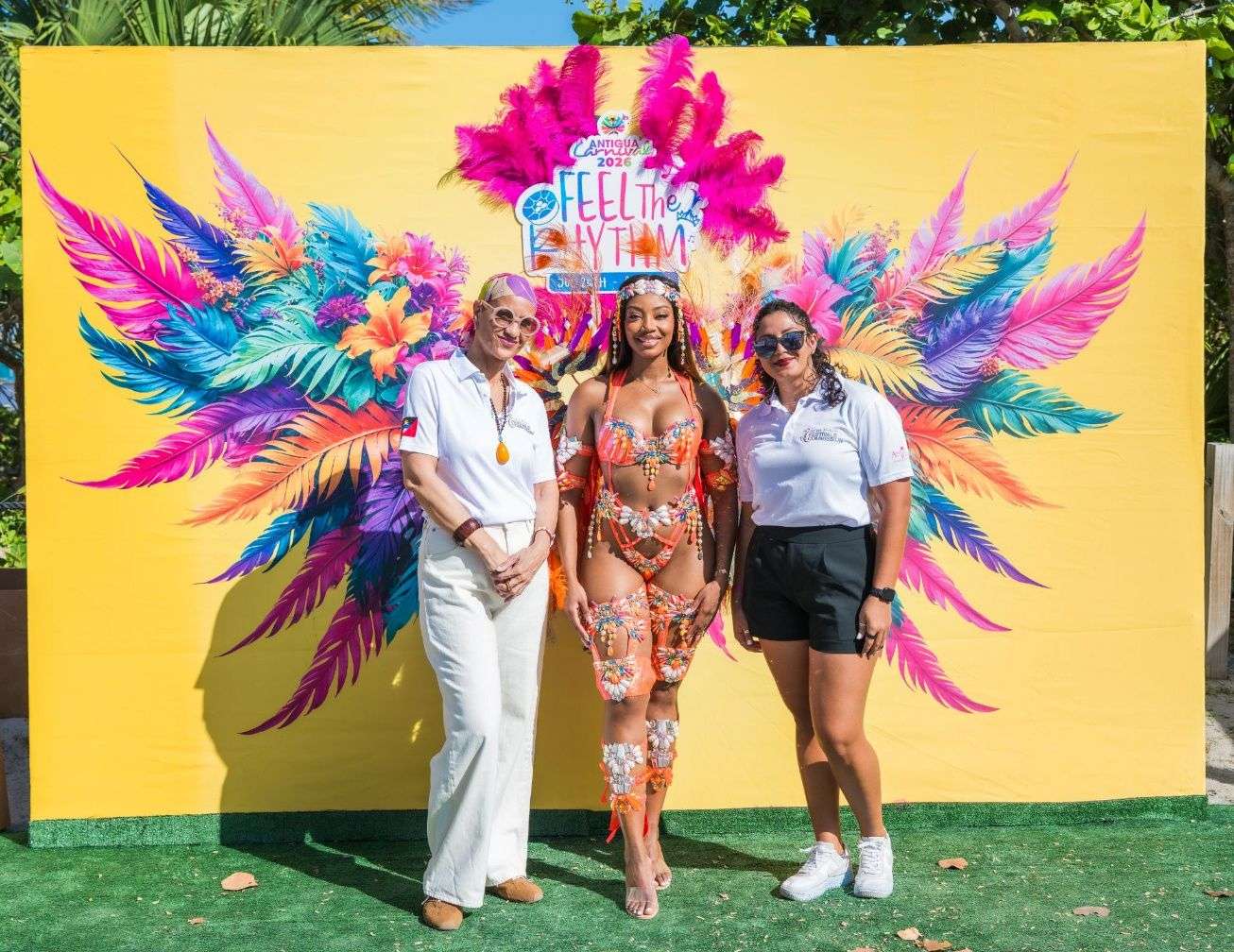 Donyelle Bird-Browne, Senior Business Development Manager, and Aliah Maginley, Sales & Marketing Officer, Southeast, pictured alongside a Carnival dancer representing the Antigua & Barbuda Festivals Commission in a design by Sechuns-The Band. Together, they helped showcase the vibrant energy of Antigua Carnival 2026, “Feel the Rhythm”. Photo Credit: Colin Subratie x FWF